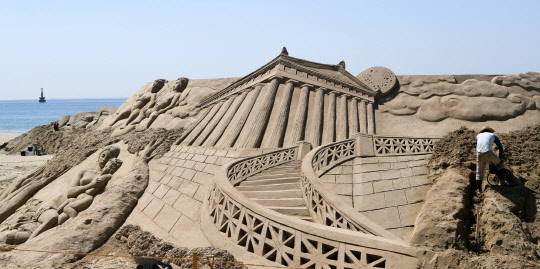 19일 부산 해운대해수욕장에서 한 모래 조각가가 오는 26∼29일 열리는 해운대모래축제에서 선보일 대형 모래 작품을 만들고 있다.